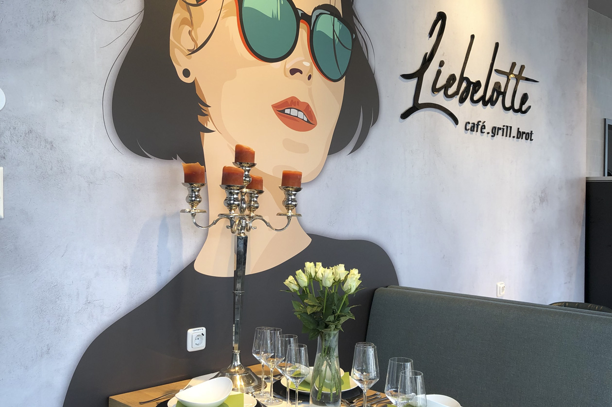Liebelotte Zeichnung und Logo an der Wand des Cafés